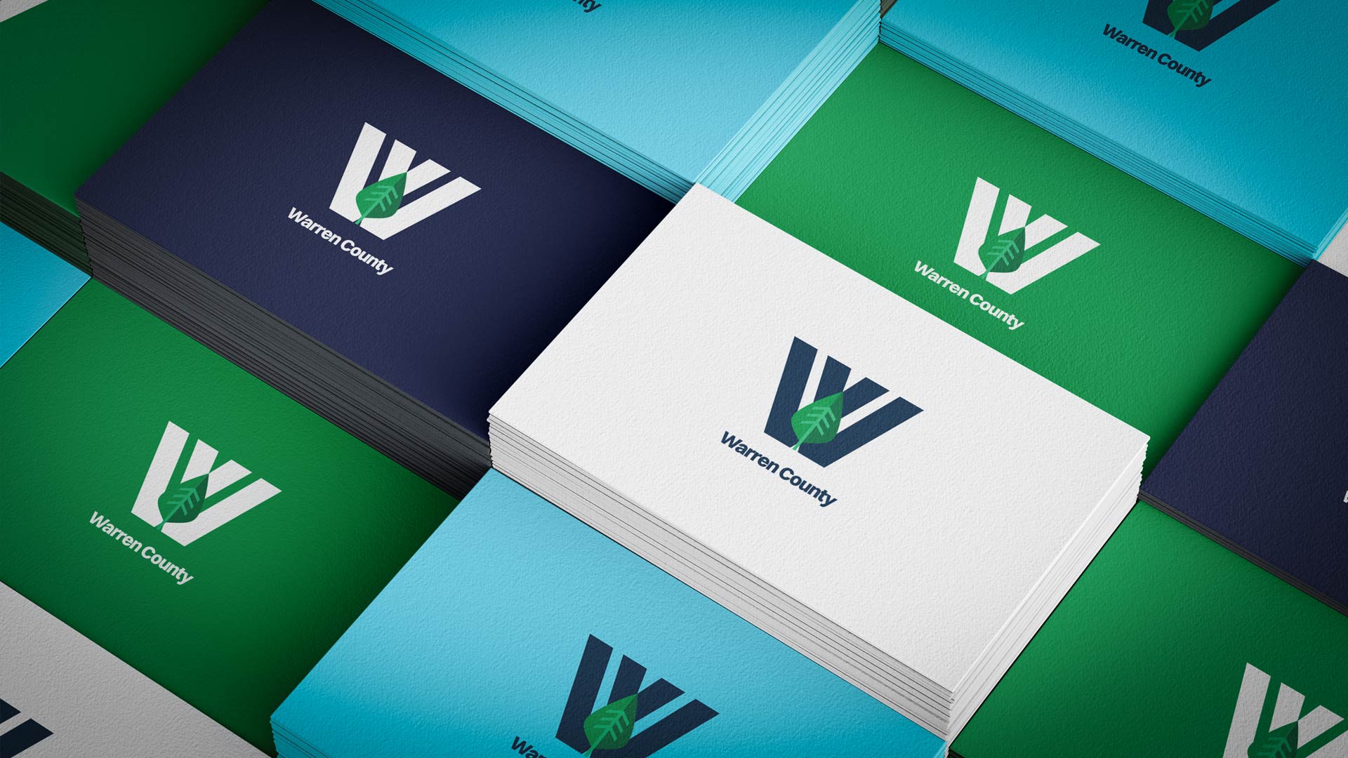 Warren County business cards in white, navy blue, green, and light blue